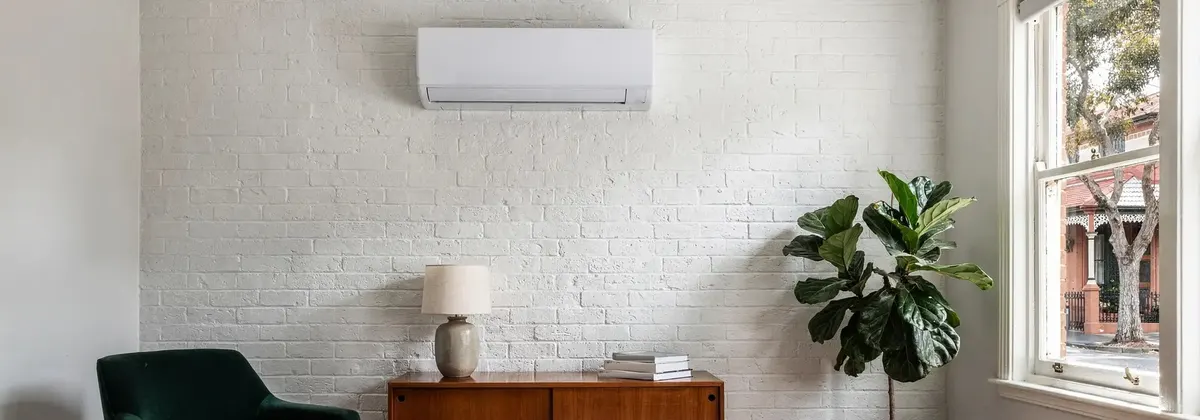 A split system on a painted white brick wall in a terrace house living room